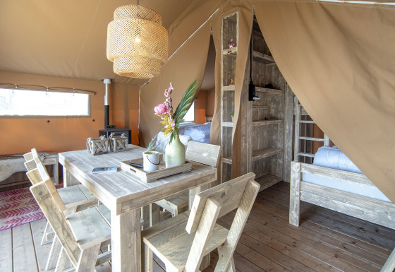 Indvendig udsigt over en hyggelig safaritelt, Safari lodge, med træmøbler ved Marina Parcs Almere, Holland.