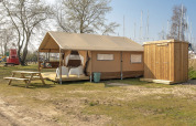 Tente Safari Lodge avec abri en bois et table de pique-nique à Marina Parcs Almere, Pays-Bas.