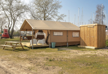 Safari-Lodge-Zelt mit Holzschuppen und Picknicktisch bei Marina Parcs Almere in den Niederlanden.