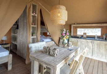 Interior de una tienda Safari Lodge en Marina Parcs Almere, Países Bajos, con muebles de madera y decoración acogedora.