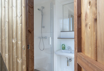Salle de bains moderne avec douche et lavabo dans une tente safari à Marina Parcs Almere, Pays-Bas.