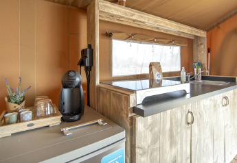 Køkkenområde i en safarilodge med kaffemaskine, vask og træelementer hos Marina Parcs Almere, Holland.