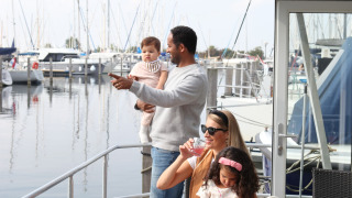 Gezin geniet van House boat 4-Almere bij Marina Parcs Almere, omringd door aangemeerde boten.