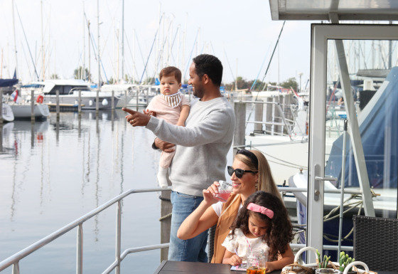 Familia disfruta en la House boat 4-Almere en Marina Parcs Almere, Países Bajos, rodeada de barcos.