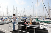 Familia disfruta en la houseboat 4-Almere en Marina Parcs Almere, Países Bajos, rodeados de veleros en el puerto.