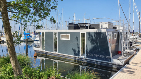 Een modern woonboot genaamd House boat 4-Almere ligt aangemeerd bij Marina Parcs Almere in Nederland.
