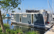 Een modern woonboot genaamd House boat 4-Almere ligt aangemeerd bij Marina Parcs Almere in Nederland.