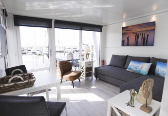 Stilfuld opholdsstue på husbåd House boat 4-Almere ved Marina Parcs Almere i Holland med udsigt over havnen.