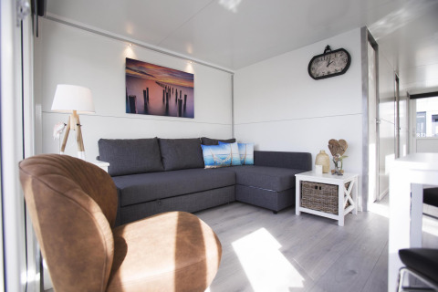 Moderne woonkamer op woonboot House boat 4-Almere bij Marina Parcs Almere, Nederland, met comfortabele bank.