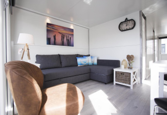 Soggiorno moderno sulla houseboat House boat 4-Almere a Marina Parcs Almere, Paesi Bassi, con divano.