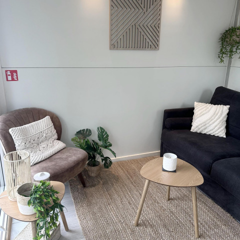 Hyggelig stue på en husbåd i Almere med moderne møbler, grønne planter og neutrale farver.