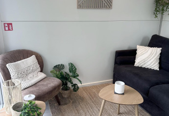 Hyggelig stue på en husbåd i Almere med moderne møbler, grønne planter og neutrale farver.