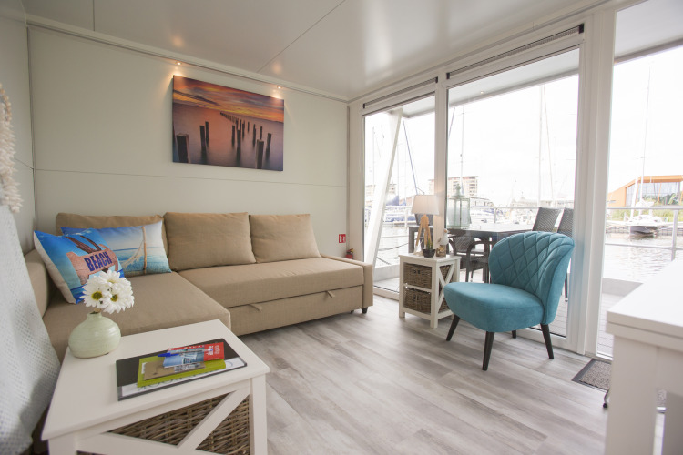 Interior de la House boat 4-Almere en Marina Parcs Almere, Países Bajos, con sofá y vista al puerto.