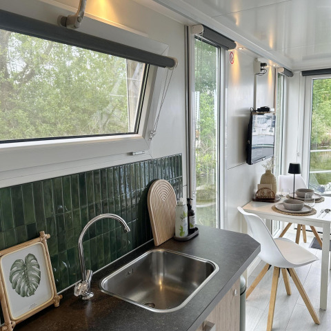 Moderne keuken en eetgedeelte met groene tegels op House boat 4-Almere, Marina Parcs Almere, Nederland.