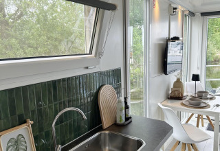 Cocina y comedor modernos con azulejos verdes en un houseboat en Marina Parcs Almere, Países Bajos.