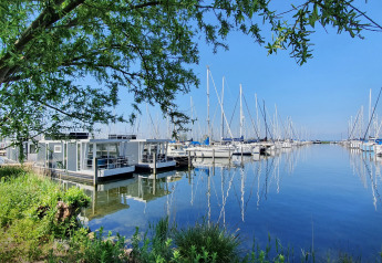 Foto della houseboat House boat 4-Almere al Marina Parcs Almere, circondata da barche a vela nei Paesi Bassi.