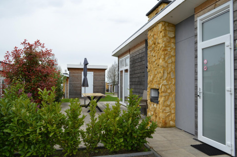 Udendørs udsigt over Biebosch-tuinhuis ved Resort Mooi Bemelen i Holland med terrasse og buske.