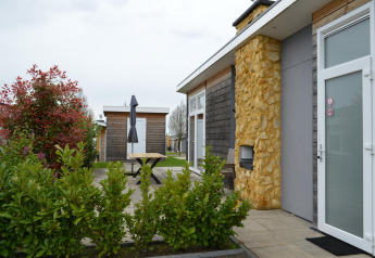 Außenansicht der Biebosch-Lodge im Resort Mooi Bemelen, Niederlande, mit Terrasse und Garten.