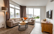 Moderne stue i Biebosch - tuinhuis ved Resort Mooi Bemelen, Holland, med store vinduer og komfortabel sofa.