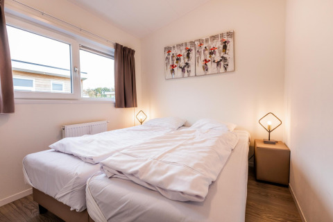 Slaapkamer in Biebosch - tuinhuis op Resort Mooi Bemelen in Nederland met tweepersoonsbed en moderne sfeer.