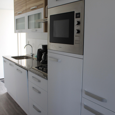 Cocina moderna con horno empotrado y cafetera en Biebosch - tuinhuis en Resort Mooi Bemelen, Países Bajos.