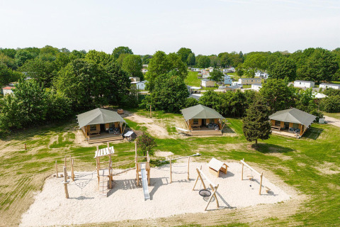 Vue aérienne des tentes safari Villatent Cottage et aire de jeux au Camping Borken am See en Allemagne.