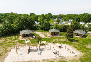 Vue aérienne des tentes safari Villatent Cottage et aire de jeux au Camping Borken am See en Allemagne.