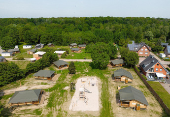 Vista aérea de tiendas safari Villatent Cottage y área de juegos en Camping Borken am See, Alemania, rodeado de naturaleza.
