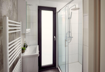 Baño moderno en la villa Holiday Amalia 6 en Hofparken De Bergvennen, Países Bajos, con ducha acristalada.