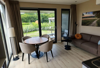 Modern living room at Vacation Villa Amalia 2 with garden view, sauna, and hot tub at Hofparken De Bergvennen.