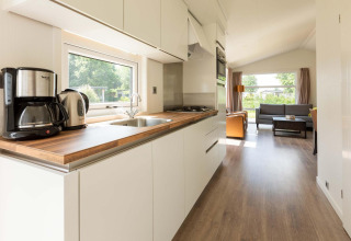 Moderne Comfort cabin bij EuroParcs Noordwijkse Duinen met lichte keuken en woonkamer, Nederland.