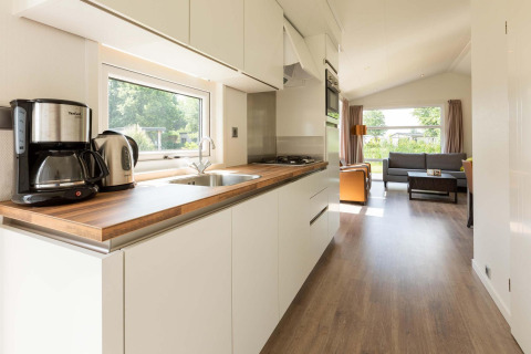 Moderne Comfort cabin bij EuroParcs Noordwijkse Duinen met een lichte keuken en woonkamer, Nederland.