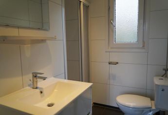 Badkamer met wastafel, spiegel, wc en raam in een Comfort cabin bij EuroParcs Noordwijkse Duinen, Nederland.