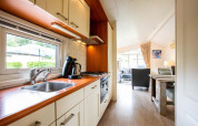 Helles Ferienhaus bei EuroParcs Noordwijkse Duinen, Niederlande, mit Küche, Wohnzimmer und Essbereich.