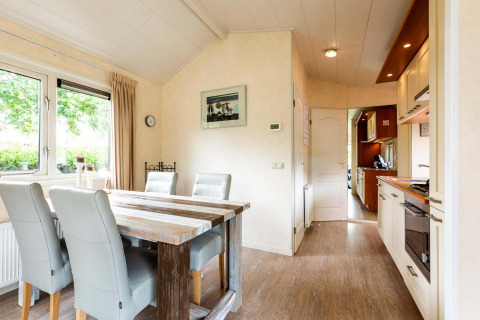 Luminoso soggiorno con tavolo da pranzo e cucina moderna in una casa vacanza a EuroParcs Noordwijkse Duinen, Paesi Bassi.