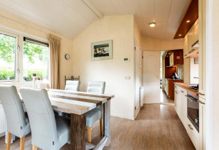 Luminoso comedor y cocina moderna en una cabaña de vacaciones en EuroParcs Noordwijkse Duinen, Países Bajos.