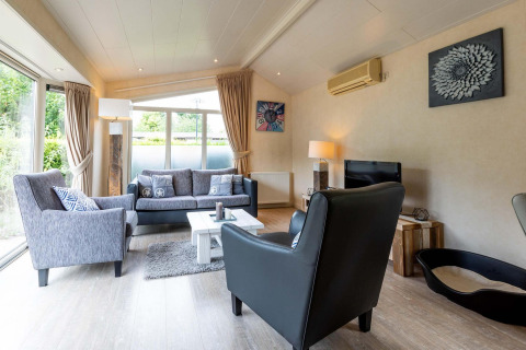 Lichte, sfeervolle woonkamer in vakantieverblijf bij EuroParcs Noordwijkse Duinen, Nederland, met modern interieur.