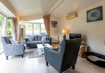 Lichte, sfeervolle woonkamer in vakantieverblijf bij EuroParcs Noordwijkse Duinen, Nederland, met modern interieur.