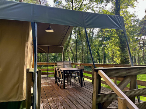 Safari-Zelt Summer Lodge bei Beerze Bulten in den Niederlanden mit Holzterrasse und Sitzmöbeln.