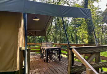Safari-Zelt Summer Lodge bei Beerze Bulten in den Niederlanden mit Holzterrasse und Sitzmöbeln.