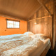 Chambre confortable dans une tente safari Summer Lodge à Beerze Bulten, aux Pays-Bas, avec murs en bois.