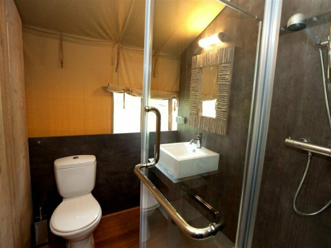 Badkamer van safaritent Summer Lodge bij Beerze Bulten in Nederland met toilet, wasbak en douche.