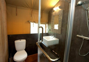 Badkamer van safaritent Summer Lodge bij Beerze Bulten in Nederland met toilet, wasbak en douche.