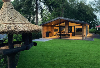 Modernes Familien-Lodge Deluxe bei De Thijmse Berg, Niederlande, mit Terrasse und grüner Rasenfläche.