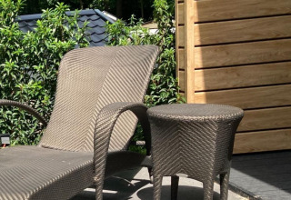 Sonnige Terrasse mit Liegestuhl und Tisch bei Family Lodge Deluxe, De Thijmse Berg, Niederlande.