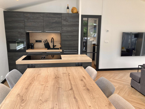 Cocina moderna y comedor en la Family Lodge Deluxe de De Thijmse Berg, Países Bajos, con decoración elegante.