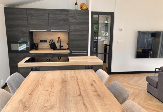 Cocina moderna y comedor en la Family Lodge Deluxe de De Thijmse Berg, Países Bajos, con decoración elegante.