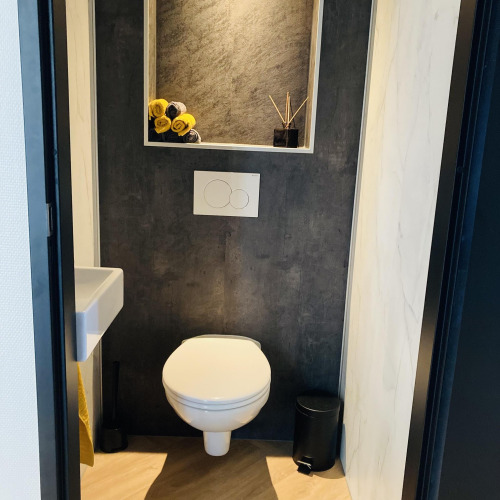 Baño moderno en Family Lodge Deluxe de De Thijmse Berg, Países Bajos, con estante empotrado y pared oscura.