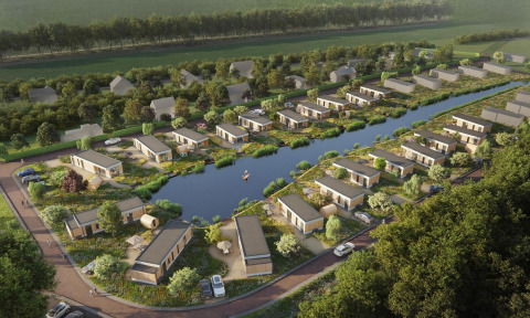 Luchtbeeld van hedendaagse lodges rond een vijver, met veel groen en geparkeerde auto's aan de huisjes.