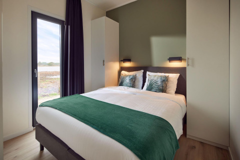 Dormitorio moderno en Water lodge 6 Deluxe con sauna y jacuzzi en Hofparken Wiltershaar, Países Bajos.